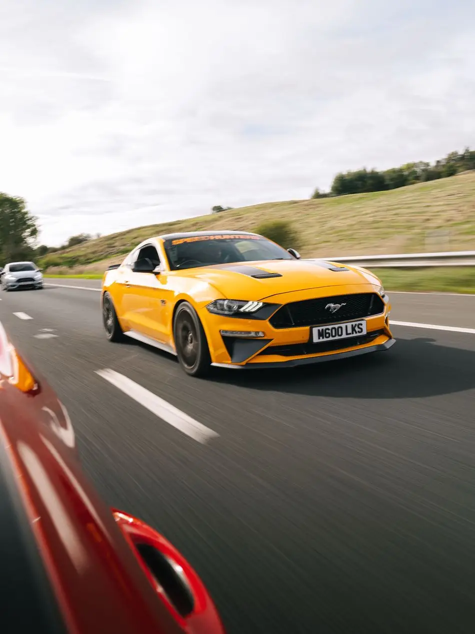 Orange Ford Mustang on the road